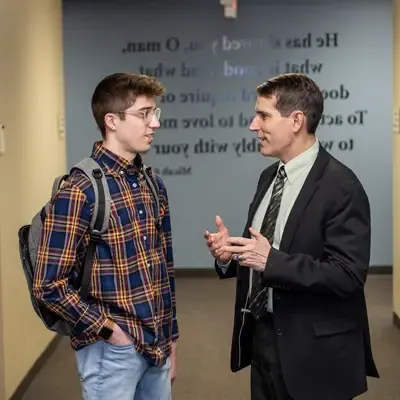 Professor and student talking in a hallway.