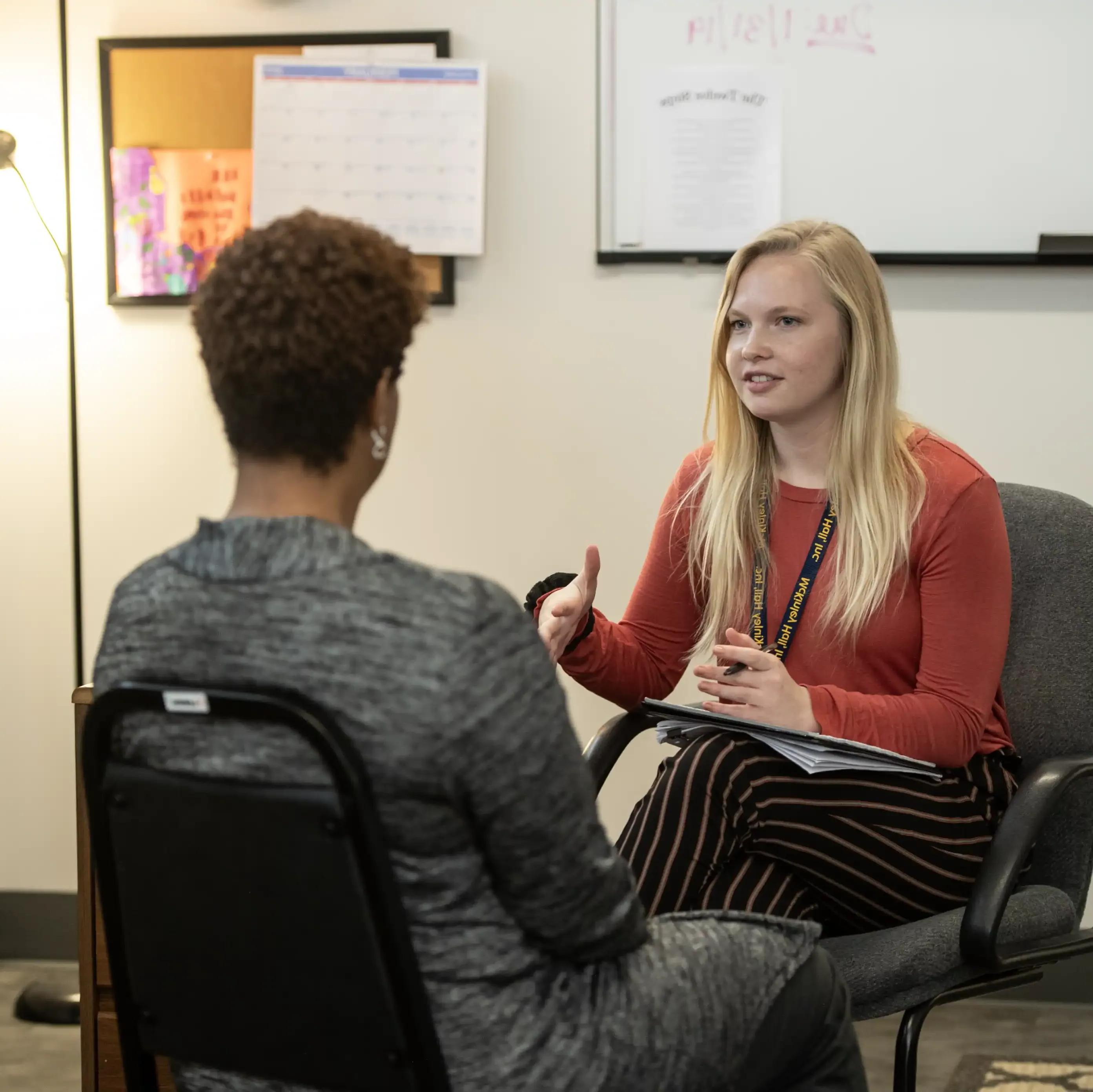 Two females seated discussing an issue.