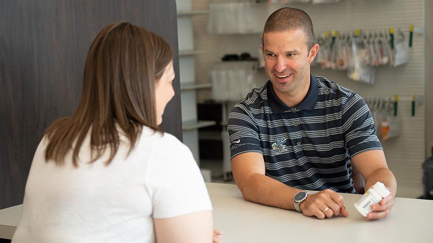 Dr. Thad Franz, pharmacist at Cedar Care Village Pharmacy, speaking with a patient