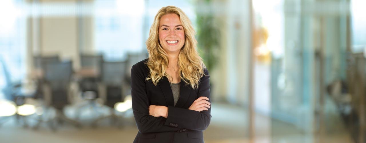 Female looking at camera and smiling with her arms crossed in a building