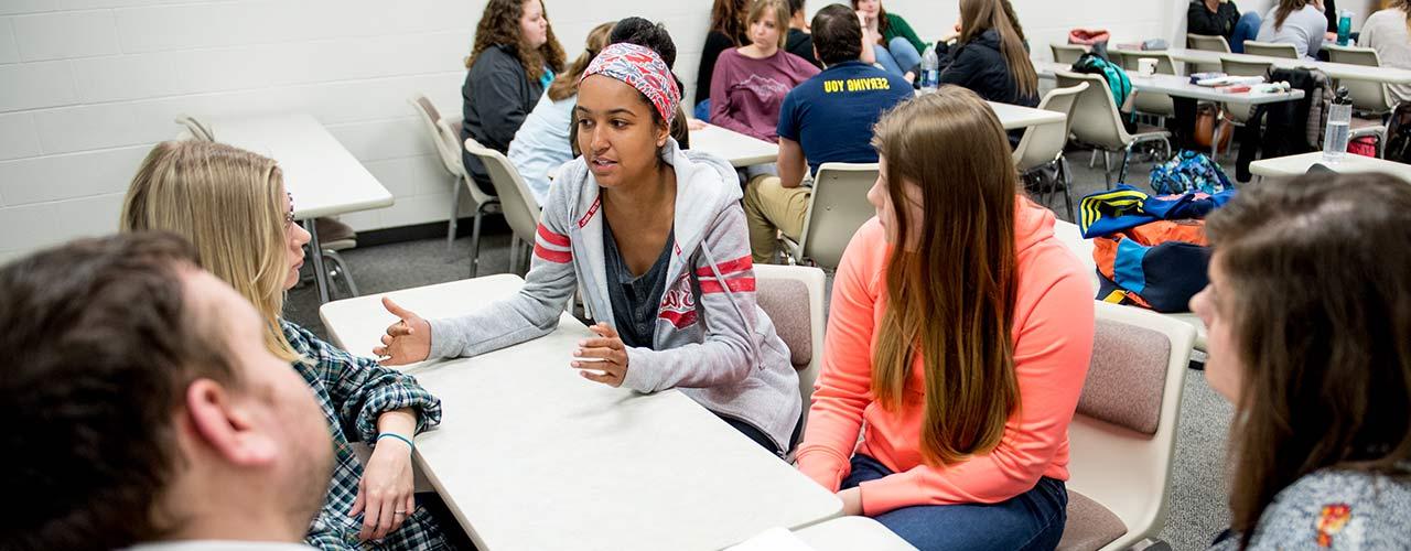 Female social work students discuss around a table