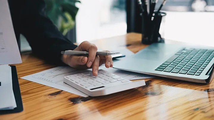 Person using a calculator at a desk.