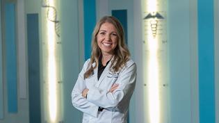 Female student posing in white pharmacy coat