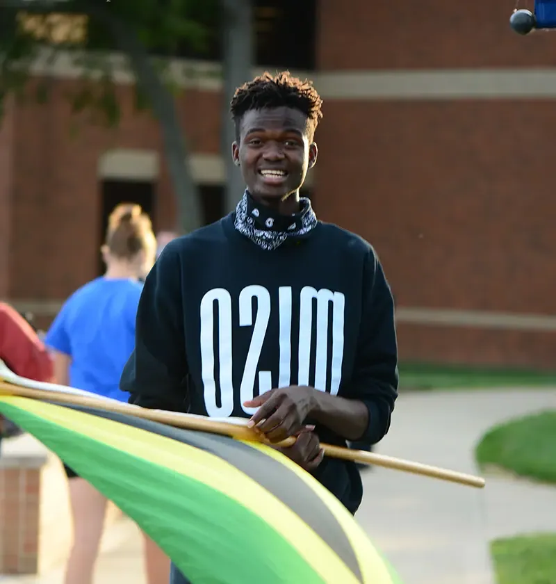 Guy with MISO sweatshirt standing, holding the Jamaican flag